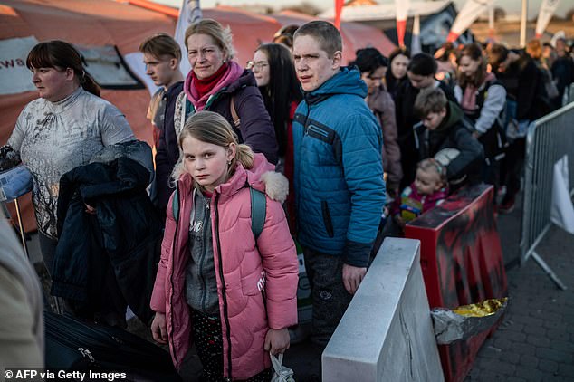 Refugees from Ukraine queue as they wait for further transport at the Medyka border crossing, after crossing at the Ukrainian-Polish border, southeastern Poland, on March 23