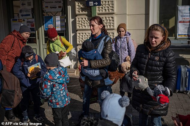 Sex traffickers are targeting Ukrainian women and children who have fled Vladimir Putin's bombs at Polish refugee camps, charities have warned. Pictured: Women with children are seen outside the train station Przemysl, southeastern Poland, near the Polish-Ukrainian border, on Thursday