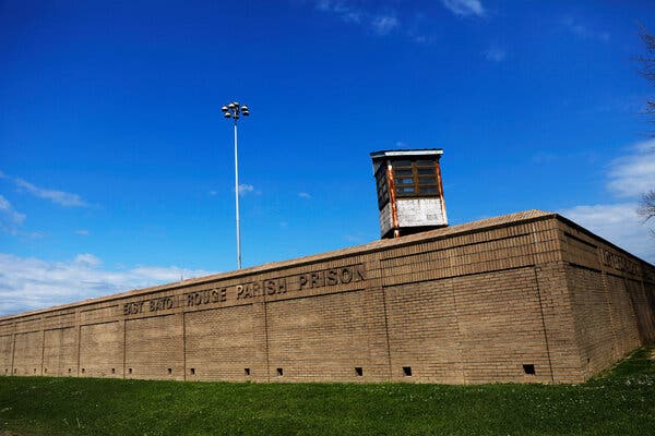 A brown brick wall with the words “East Baton Rouge Parish Prison.”