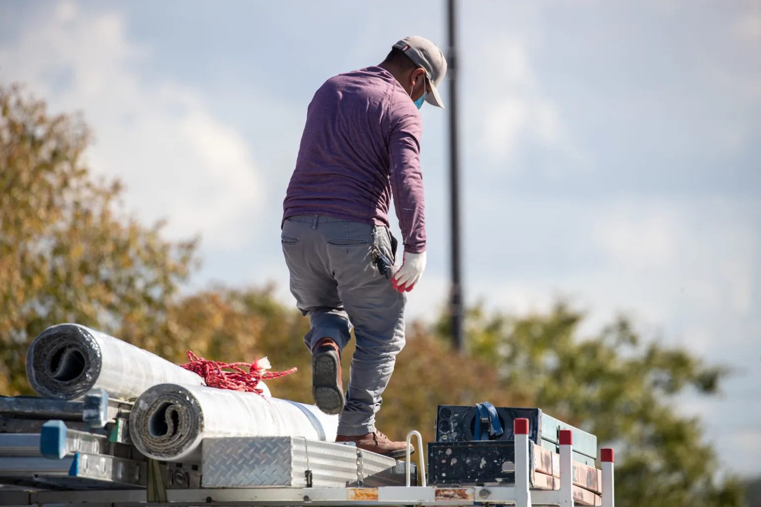 Photo of a man standing on top of supplies in a work truck.