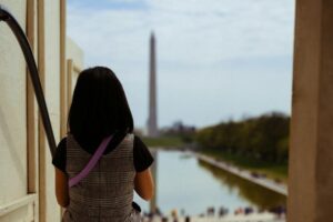 girl with her back to viewer and the Washington Monument in the background
